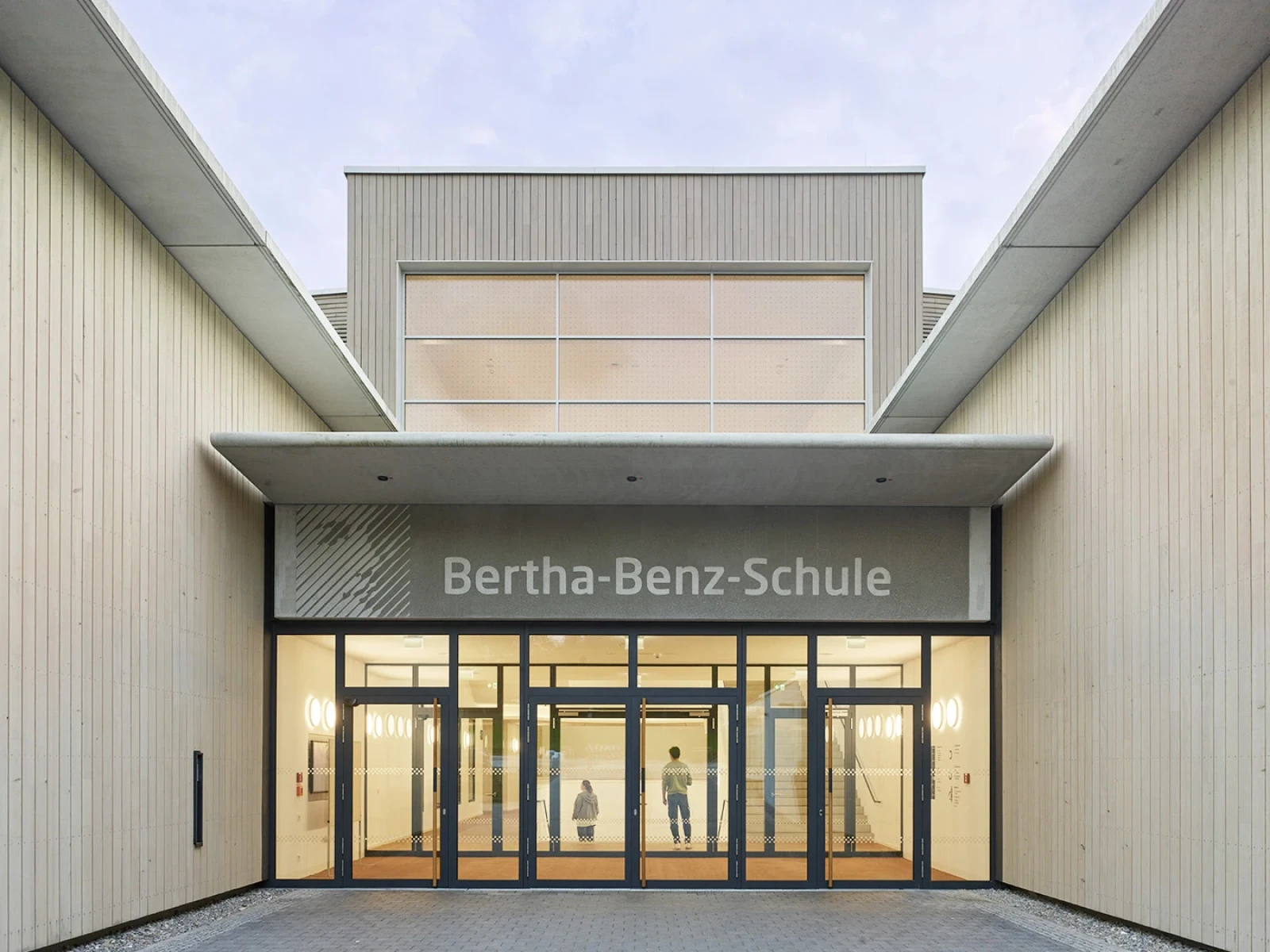 Am Schnittpunkt der beiden Baukörper entstand mit der großzügige Haupttreppe ein zentrales Gestaltungselement, das den nördlichen und südlichen Eingang verbindet und eine klare, intuitive Orientierung bietet.