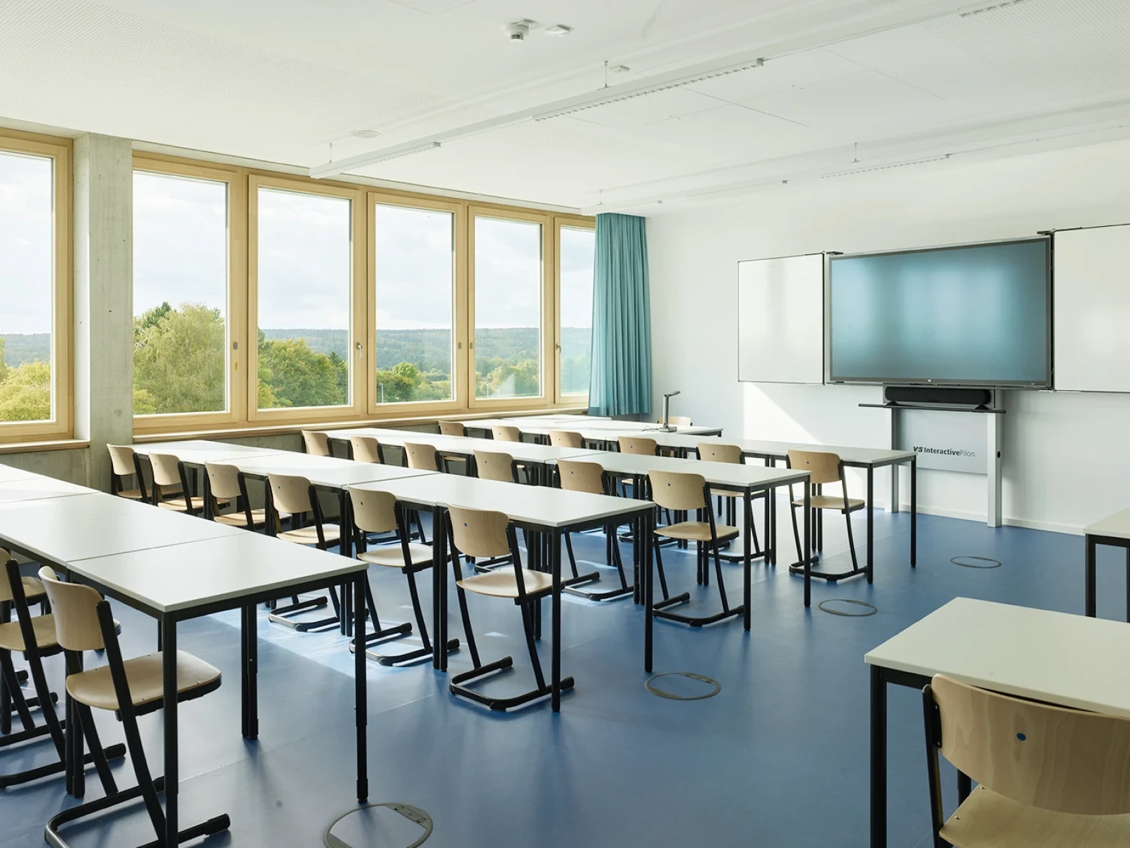 Im Innenraum sorgen natürliche Materialien wie Holzoberflächen, Parkett, Fensterbänke und Türen für Wärme und Haptik und liegen im ausgewogenen Kontrast zum Sichtbeton und Linoleum.