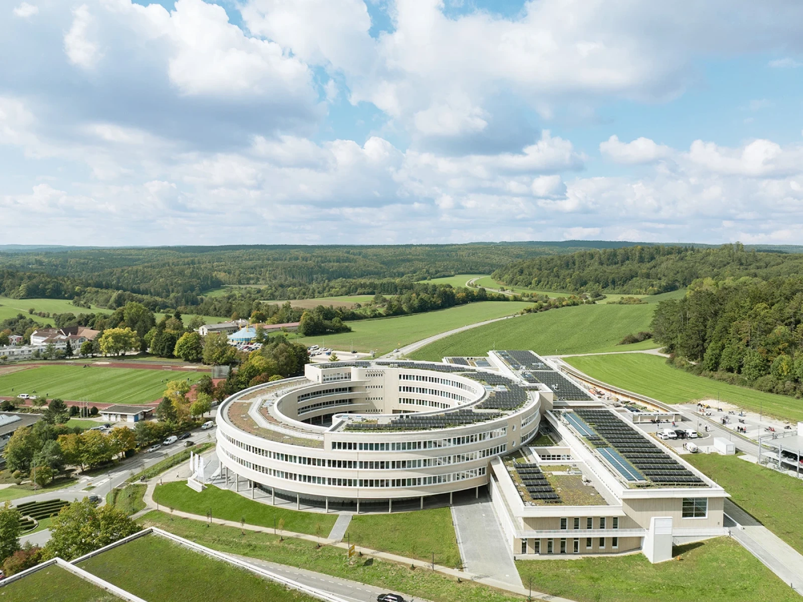 Der Entwurf nutzt die verfügbaren Flächen effizient und bildet mit der Kreismitte das lebendige Zentrum des Campus – ein einladender Außenbereich, der Aula Vorplatz, Veranstaltungsfläche und Treffpunkt verbindet.